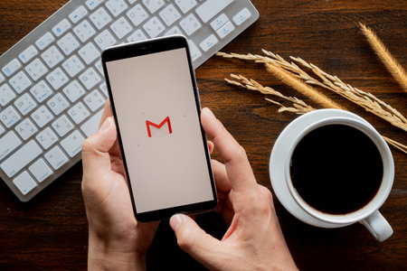 Chiang Mai / Thailand - jan 20 2019 : Hands hoding mobile with email screen, Coffee and keyboard on...