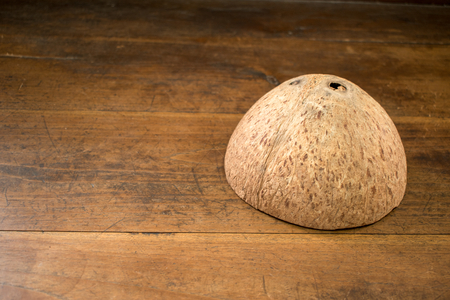 Coconut shell upside down on a wooden backgroundの写真素材