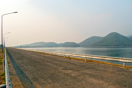 Road on the edge of the dam, which has a nature background.の写真素材