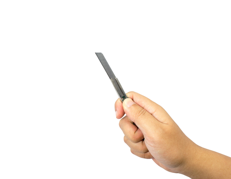 A hand holding a cutter knife and available in cutting. Isolated on white background.の写真素材