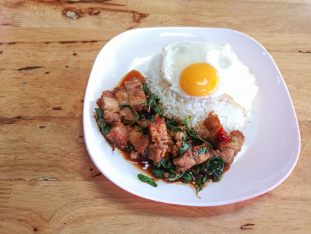 Stir fried spicy crispy pork with thai basil and fried egg. Closed up Popular Thai-food.の写真素材
