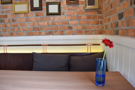 Red Flowers in a glass on the table. Brick wall and frame Background .の写真素材