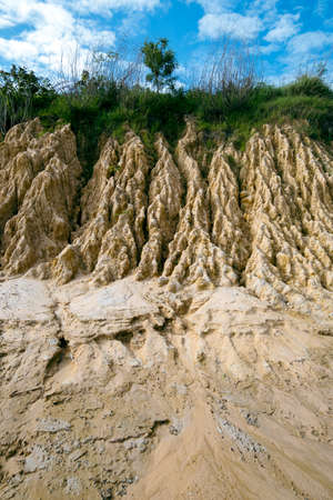 A pile of soil that has been eroded into a large rut when it rains.の写真素材