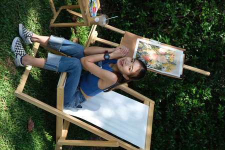 girl sitting in the garden on the green grassの写真素材