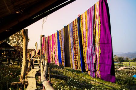 Woven cloth was put on the clothesline behind the Lamduan Woven shop.の写真素材