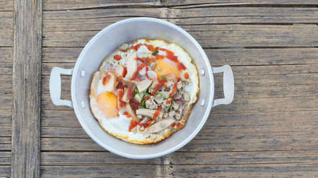 Top view picture of Vietnamese fried eggs in an aluminum dish placed on a wooden table.の写真素材