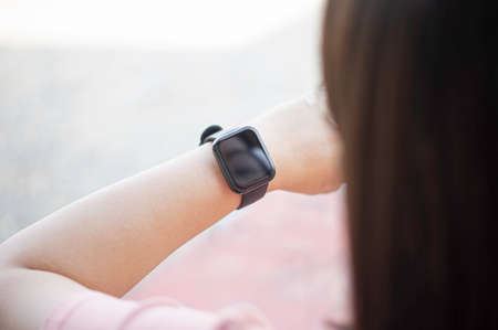 Close up black smartwatch on the wrist of an Asian woman. And there is free space for writing messages. Concept smartwatch in lift style.の写真素材