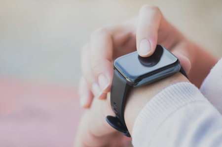 Close up black smartwatch on the wrist of an Asian woman. And there is free space for writing...