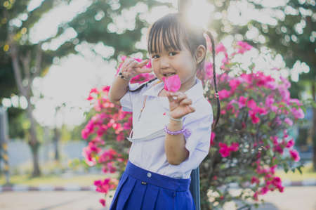 PHRAE, THAILAND â NOVEMBER 20: Asian girl in kindergarten uniforms relaxes outside the building on the December 20,2021 in PHRAE,TH.のeditorial素材