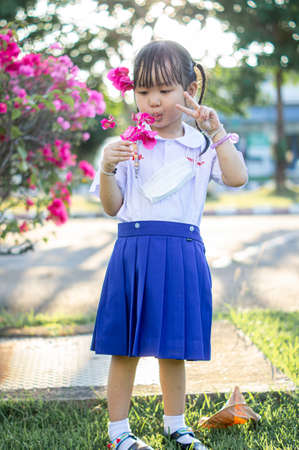 PHRAE, THAILAND â NOVEMBER 20: Asian girl in kindergarten uniforms relaxes outside the building on the December 20,2021 in PHRAE,TH.のeditorial素材