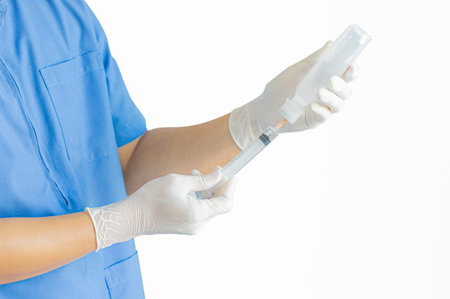 A surgeon wearing a blue uniform stands with his thumbs up on a white background.