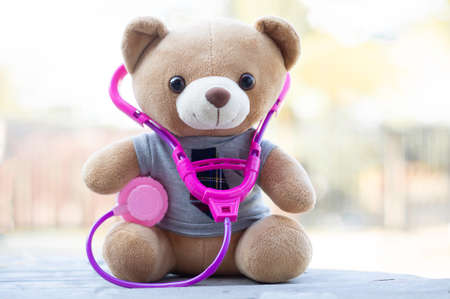Vertical photo Brown teddy bears wore a stethoscope around the neck. Health care concept. And free space for your text.の写真素材