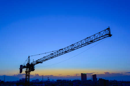 Industrial construction cranes and building in the sunsetの写真素材