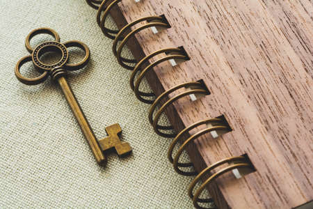 Gold key and spiral notebook on the canvas background, vintage colorの写真素材