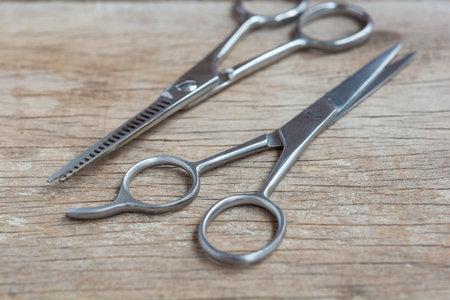 Steel scissors on wooden background with selective focus