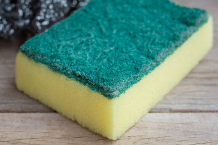 Dishwashing sponge on wooden background