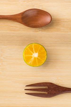 Fresh oranges and wooden spoon on the wooden backgroundの写真素材