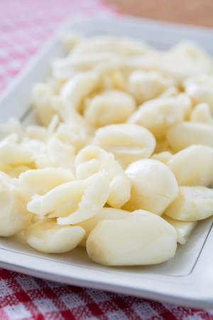 Peeled garlic in a white plateの写真素材