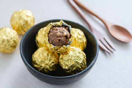 Chocolate ball with golden foil in a black cupの写真素材