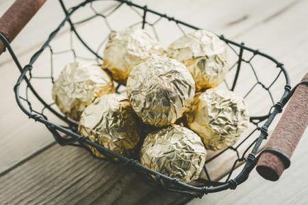 Chocolate ball with golden foil in a basket, vintage color toneの写真素材