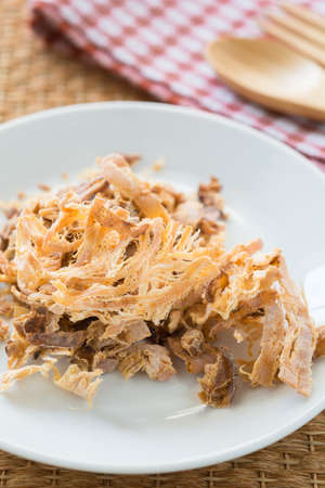 Shredded seasoned cuttlefish on a white dishの写真素材