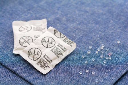 Desiccant or silica gel in paper sachet on blue fabric backgroundの写真素材