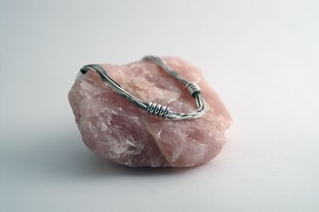 Sterling silver necklace placed on a rock of rose quartz.の写真素材