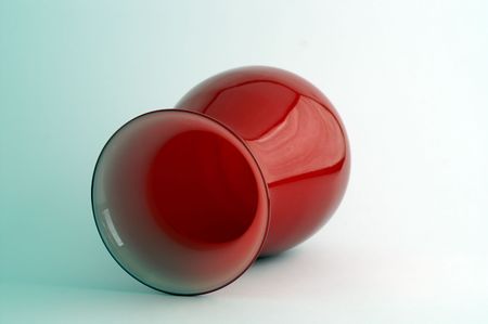 Big red flower vase lying down, green gradient background.の写真素材