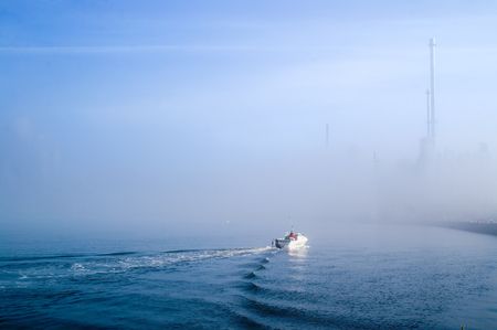 Boat sailing in misty watersの写真素材