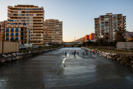 Maintenance and cleaning the river floor in a city, urban setting, early in the morning.の写真素材