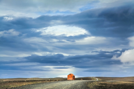 Panoramic view of barren landscape with old red snowstorm shelter at Kjolur highland road, Icelandの写真素材