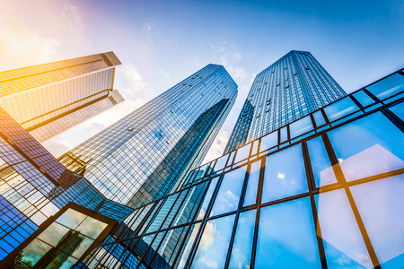 Bottom view of modern skyscrapers in business district at sunset with lens flare filter effect