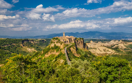 Beautiful view of famous Civita di Bagnoregio with Tiber river valley in golden evening light, Lazio, Italyの写真素材