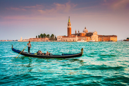 Traditional Gondola on Canal Grande with San Giorgio Maggiore church in the background at sunset, San Marco, Venice, Italyの写真素材