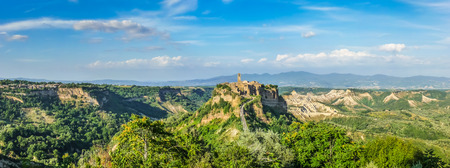 Beautiful panoramic view of famous Civita di Bagnoregio with Tiber river valley in golden evening light, Lazio, Italyの写真素材