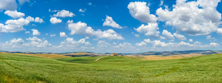 Scenic Tuscany landscape with rolling hills and traditional farm house in Val d'Orcia, Italyの写真素材