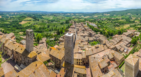 Aerial wide-angle view of the historic town of San Gimignano with Tuscan countryside on a sunny day, Tuscany, Italyの写真素材