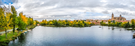 Beautiful panoramic view of the historic city of Salamanca with Rio Tormes and New Cathedral from Enrique Esteban bridge in autumn, Castilla y Leon region, Spainの写真素材