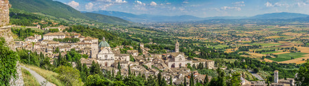 Panoramic view of the ancient town of Assisi and vast plain with golden and green harvest fields, Umbria, Italyの写真素材