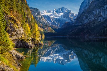 Beautiful view of idyllic colorful autumn scenery with Dachstein mountain summit reflecting in crystal clear Gosausee mountain lake in fall, Salzkammergut region, Upper Austria, Austria