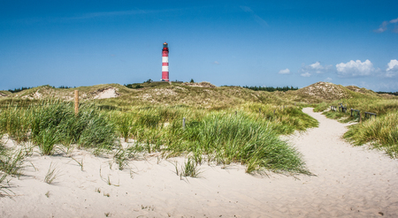 Beautiful dune landscape with traditional lighthouse on the island of Amrum at North Sea, Schleswig-Holstein, Germanyの写真素材