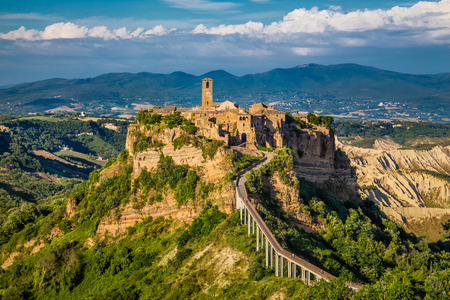Beautiful view of famous Civita di Bagnoregio with Tiber river valley in golden evening light, Lazio, Italyの写真素材
