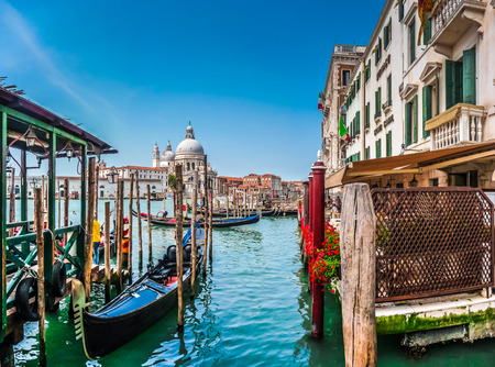 Beautiful view of traditional Gondola on Canal Grande with historic Basilica di Santa Maria della Salute in the background on a sunny day in Venice, Italyの写真素材