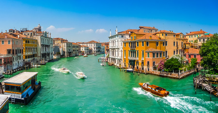 Panoramic view of typical Canal Grande scene with colorful houses and busy boats and gondolas on a  sunny day in Venice, Italyの写真素材