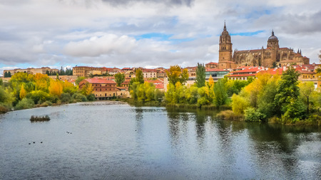 Beautiful panoramic view of the historic city of Salamanca with Rio Tormes and New Cathedral from Enrique Esteban bridge in autumn, Castilla y Leon region, Spainの写真素材