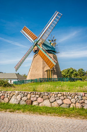 Traditional windmill in beautiful scenery with blue sky and clouds on a sunny day in summerの写真素材