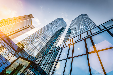 Bottom view of modern skyscrapers in business district at sunset with lens flare filter effectの写真素材