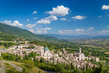Panoramic view of the historic town of Assisi on a beautiful sunny day with blue sky and clouds in summer, Umbria, Italyの写真素材