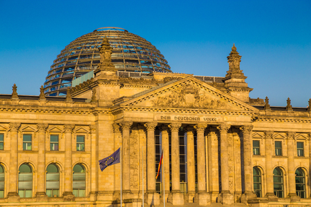 Close-up view of famous Reichstag building, seat of the German Parliament (Deutscher Bundestag), in beautiful golden evening light with blue sky at sunset, central Berlin Mitte district, Germanyの写真素材