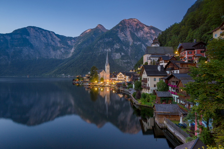 Scenic picture-postcard view of famous historic Hallstatt mountain village with Hallstattersee in the Austrian Alps in mystic twilight during blue hour at dawn in summer, Salzkammergut region, Austriaの写真素材